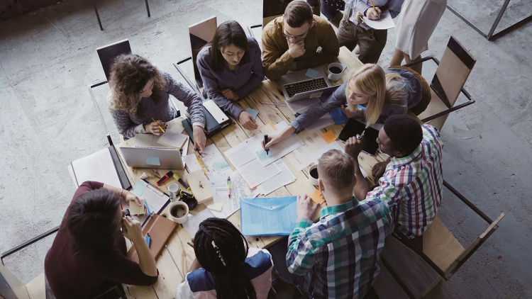 a group of college students, seen from above, working together around a table