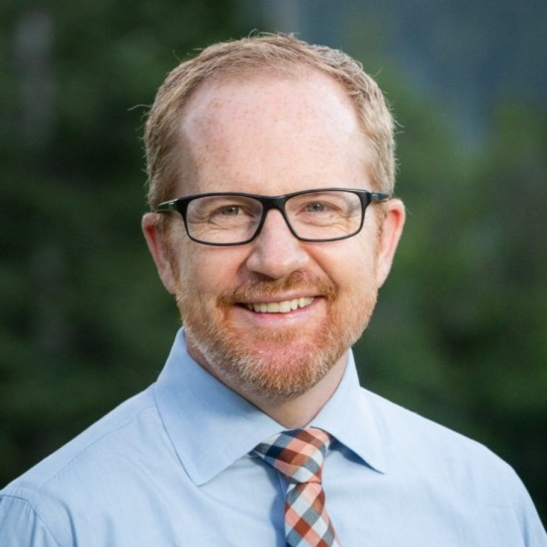 Rob Wessman wears a blue shirt and glasses